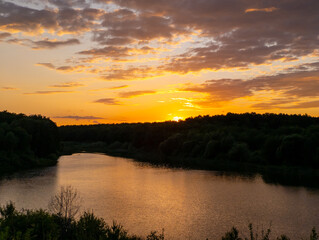 A sunset over a body of water with trees in the background