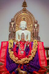 Interiors of Jain temple with the statue of Lord Mahavira or Neminath sculpted in white marble...