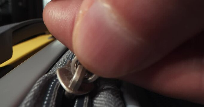 Zipper on suitcase. Zipping closing yellow travel luggage. Unrecognizable fingers pull zipper tab. Packing bags journey, adventure and fascinating exploration. Vacation dreams, preparation for travel