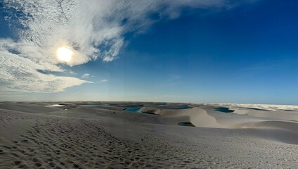 Fototapeta premium Os Lençóis Maranhenses são conhecidos por suas vastas extensões de dunas de areia branca intercaladas por lagoas de água doce cristalina, criadas pelas chuvas e lençóis freáticos. 
