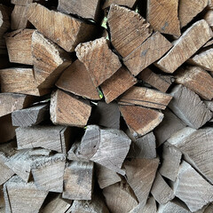 Pile of Split Oak Firewood in Neatly Arranged Stack with Brown Rough Wooden Surfaces