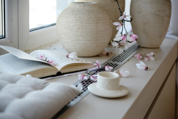 Interior, windowsill, book, cup of coffee and vase of flowers