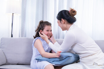 Kids, mother, bonding, beauty, nailcare, Asian mother paints her smiling Caucasian daughter’s nails during a playful home beauty session, highlight family love, mixed heritage, and happiness bonding