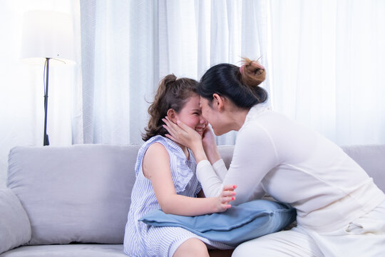 Kids, mother, bonding, beauty, love – Asian mother hugs her biracial daughter while admiring her painted nails, capturing warmth, family closeness, and joy from a shared beauty experience at home