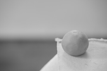 Round clay ball for pottery and sculpting on a blurred background. Raw ceramic material