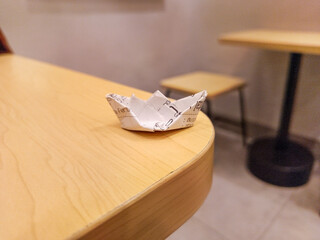 Miniature Paper Boat on Wooden Table A Simple Origami Creation