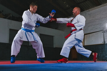Teenage Boy Practicing Karate with His Father and Instructor