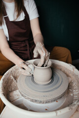 Potter shaping a ceramic artwork on a wheel. Hands in clay. Artistic pottery workshop