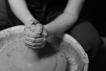 Potter shaping a ceramic artwork on a wheel. Hands in clay. Artistic pottery workshop