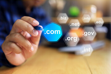 Domain name concept with businessman working on desktop to pointing a pen to selected .com to be a top level of domain in business website