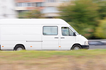 White delivery van in motion on city street