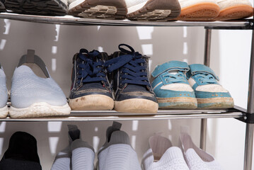 dirty shoes of all family members are on the shelf. Sorting things and decluttering