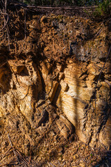 A sunlit excavation reveals layered earth and rock