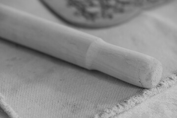 Wooden rolling pin on clay lump and canvas in ceramic workshop for pottery crafting
