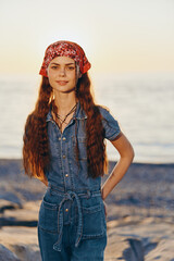 Lifestyle woman in modern boho-western denim street style with a red bandana and long hair at...