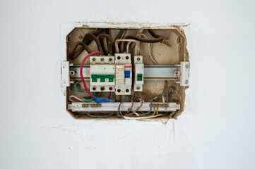 Open electrical distribution board reveals circuit breakers and wiring in a residential basement...