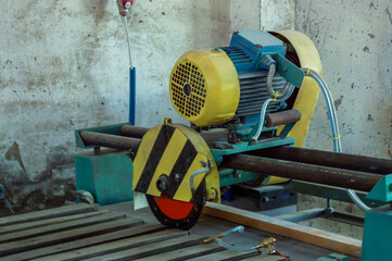 A yellow and blue cutting machine is set up in a workshop, ready for use on metal or wood...