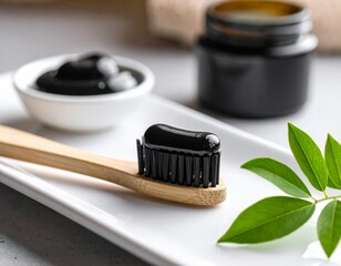 Activated Charcoal Toothpaste on Bamboo Brush with Green Leaves, Minimalist Dental Care
