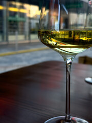 View of a glass filled with white wine standing on a restaurant table.