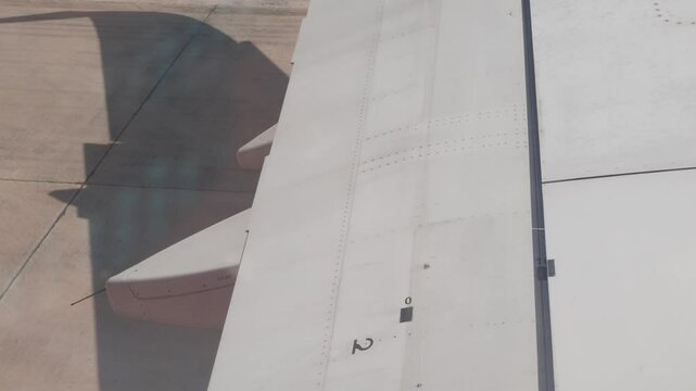 view through airplane window to the wing while aircraft push back from gate ready to travel ,aviation plane operation process background