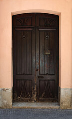A Beautiful Wooden Door featuring an Intricate Design set against a Soft Peach Background
