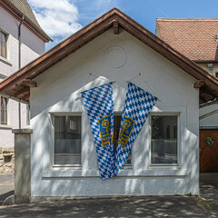 House facade with Bavarian flags hanging in Rothenburg ob der Tauber, Bavaria, Germany