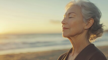Elegant senior woman practicing yoga poses at sunrise on peaceful beach setting with calm expression showcasing healthy aging lifestyle for fitness and mental wellness campaigns