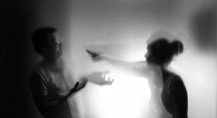 Couple arguing behind the frosted glass