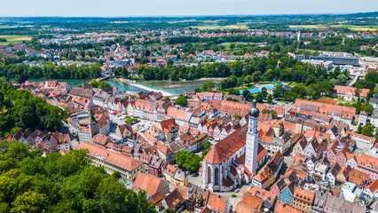 Fototapeta premium Landsberg am Lech, charming Bavarian town captured from drone. Historic old town, Lech River, Mariä Himmelfahrt Church, aquapark, small waterfall and colorful summer scenery