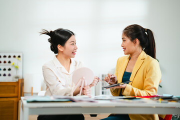 Image consultant showing color swatches and explaining personal tone selection to female client in...