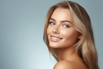 Fototapeta premium Studio portrait of a beautiful smiling blonde woman with long healthy hair showing white teeth