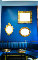 Golden picture frames on blue wall