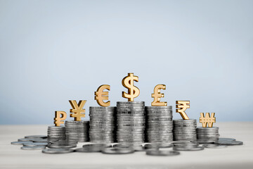 Stack of coins in rows with gold international currency symbols, Yen, Euro, Dollar, Pound, Rupee and Won. Concept of financial, monetary value, currency exchange rates and investments around the world