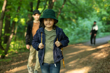Cute little kid girl go hiking trip with backpacks at mountain forest with family. Explorer and...