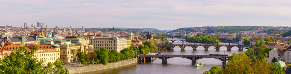 Obraz premium Panoramic view of Prague with Vltava River and historic bridges