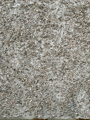 A textured wall with a surface of small, embedded pebbles, creating a unique and weathered look.