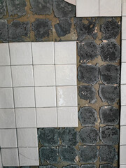 Damaged tiles with sections missing, highlighting a contrast between old and new in construction.
