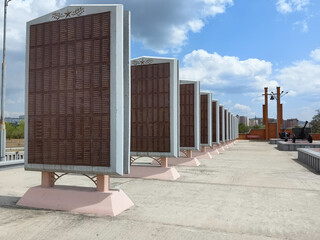 A row of memorial plaques in a park, commemorating fallen soldiers under a blue sky. Chita, Russia,...
