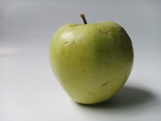 Solitary Green Apple Still Life: Subtle Wrinkles and Natural Imperfections on White Background