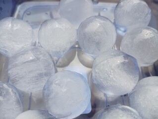 Spherical Ice Balls: Frozen Water Orbs in a Chilled Container, Refreshing and Cool