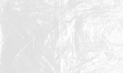 plastic transparent cellophane bag on white background. The texture looks blank and shiny. The plastic surface is wrinkly and tattered making abstract pattern