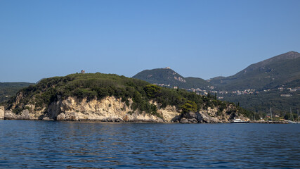 Naklejka premium Picturesque Coastal Island with Lush Greenery and Distant Town