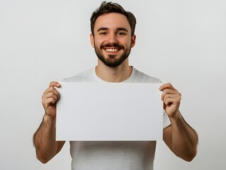 smiling man holding blank white sign for copy space, studio lighting on white background 
