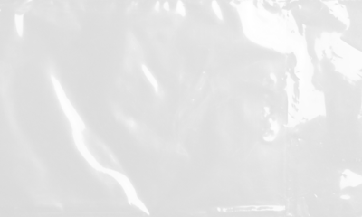 plastic transparent cellophane bag on white background. The texture looks blank and shiny. The plastic surface is wrinkly and tattered making abstract pattern