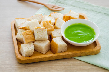 Slice steamed bread and pandan custard on wooden plate