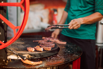 Chef fries octopus tentacles. Seafood. Mediterranean cuisine delicacy.