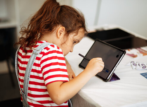 Little girl drawing on digital tablet using a digitized pen. Children's engagement of digital technology