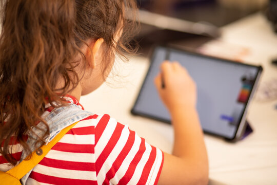 Little girl drawing on digital tablet using a digitized pen. Children's engagement of digital technology