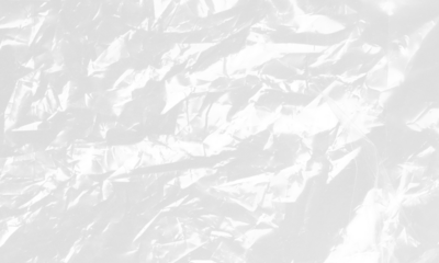 plastic transparent cellophane bag on white background. The texture looks blank and shiny. The plastic surface is wrinkly and tattered making abstract pattern