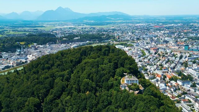 Salzburg, Austria, aerial view of the historic old town with Hohensalzburg Fortress, Salzach River, baroque architecture and surrounding Alps. Captured on a sunny summer day from a drone